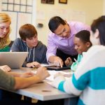 High School Students With Teacher In Class Using Laptops